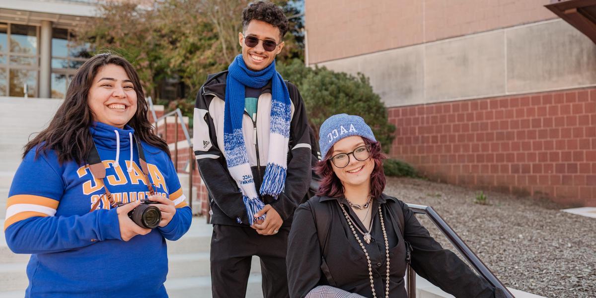 Group of students smiling outside in amphitheater.